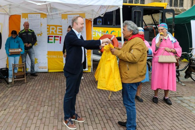 Overhandiging van de speciale gele jassen aan de werkgroep.